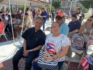 Two people smiling, holding Puerto Rican flags.