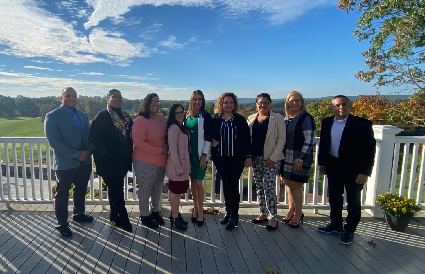 Group of people posing on a deck.