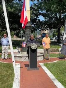 A man is speaking at an event in the park.