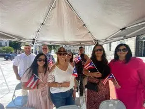 A group of people standing under an umbrella.