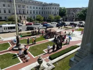 A group of people standing around in the grass.