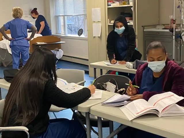 Four women in a classroom studying.