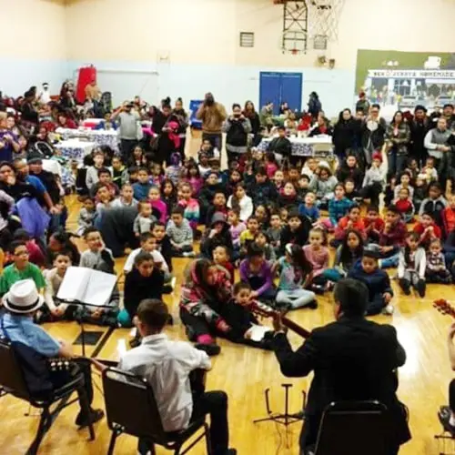 Large group of children playing music indoors.