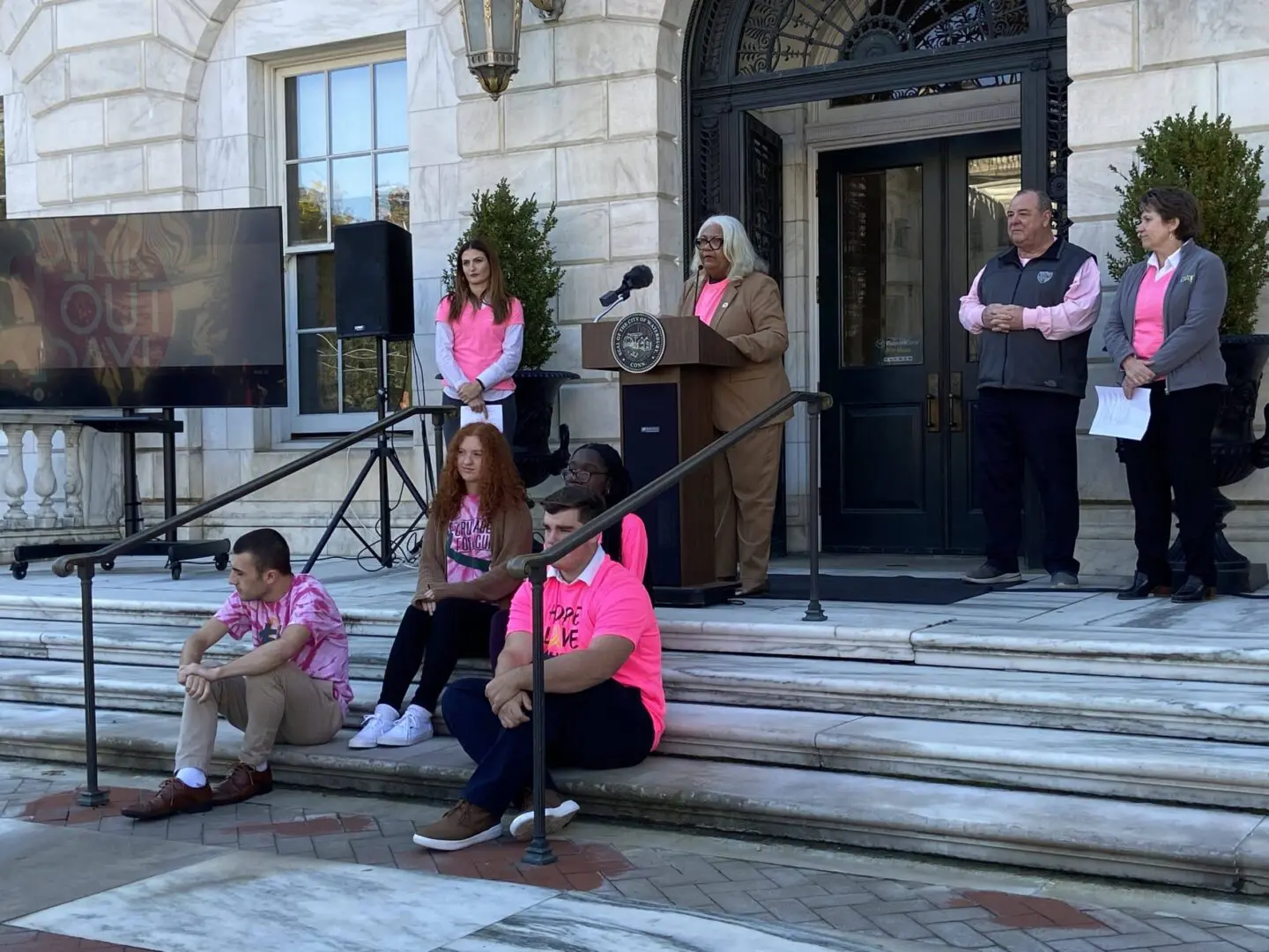 A group of people sitting on steps outside