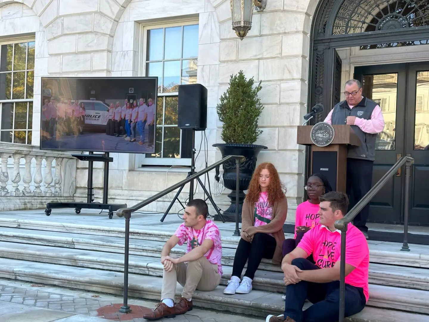 People in pink shirts at a rally.