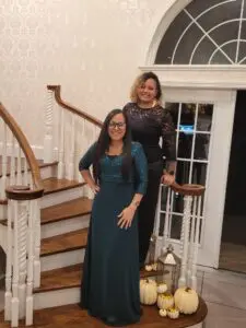 Two women standing on a set of stairs.