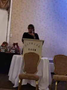 Woman speaking at podium in Crystal Room.