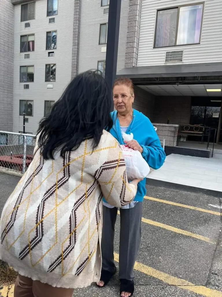Two women standing outside an apartment building.