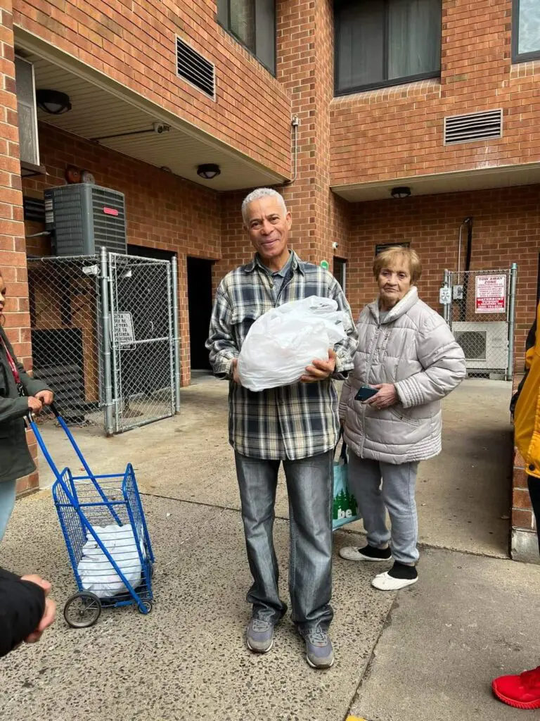 Two people standing outside with bags.