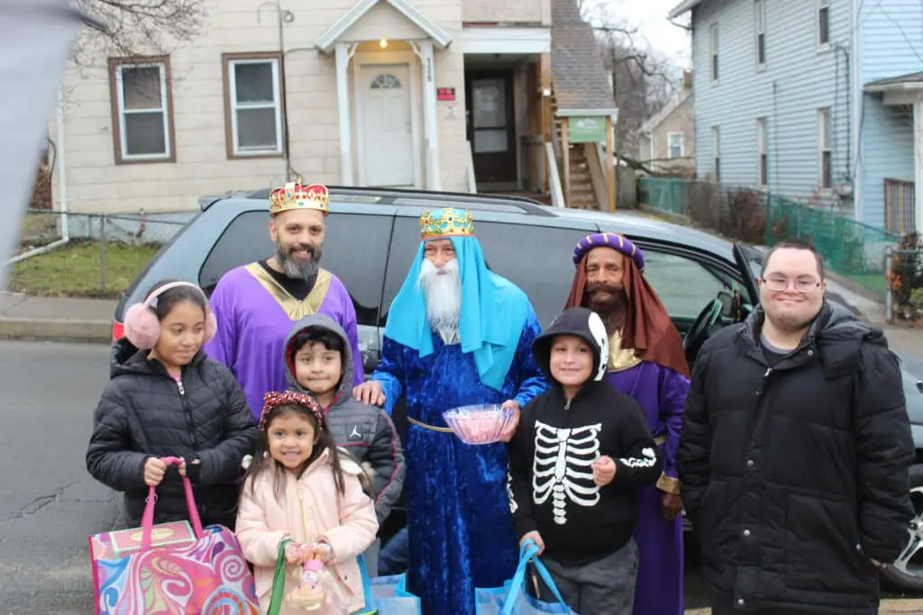 Three Wise Men with children in front of a car.