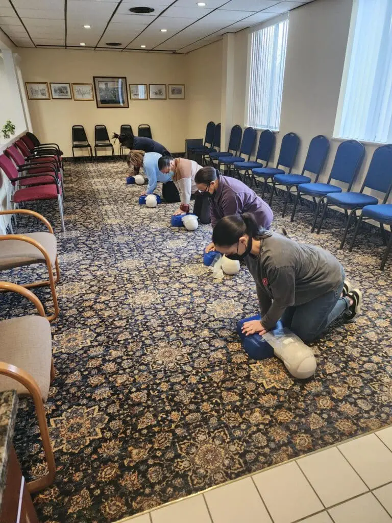 A group of people practicing cpr on the floor.