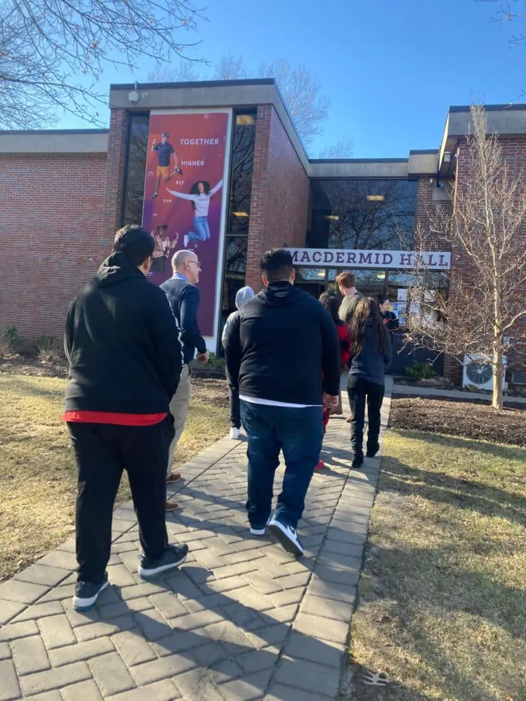 A group of people standing on the sidewalk.