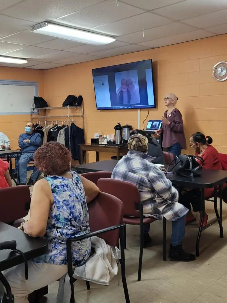 A group of people sitting around in front of a tv.