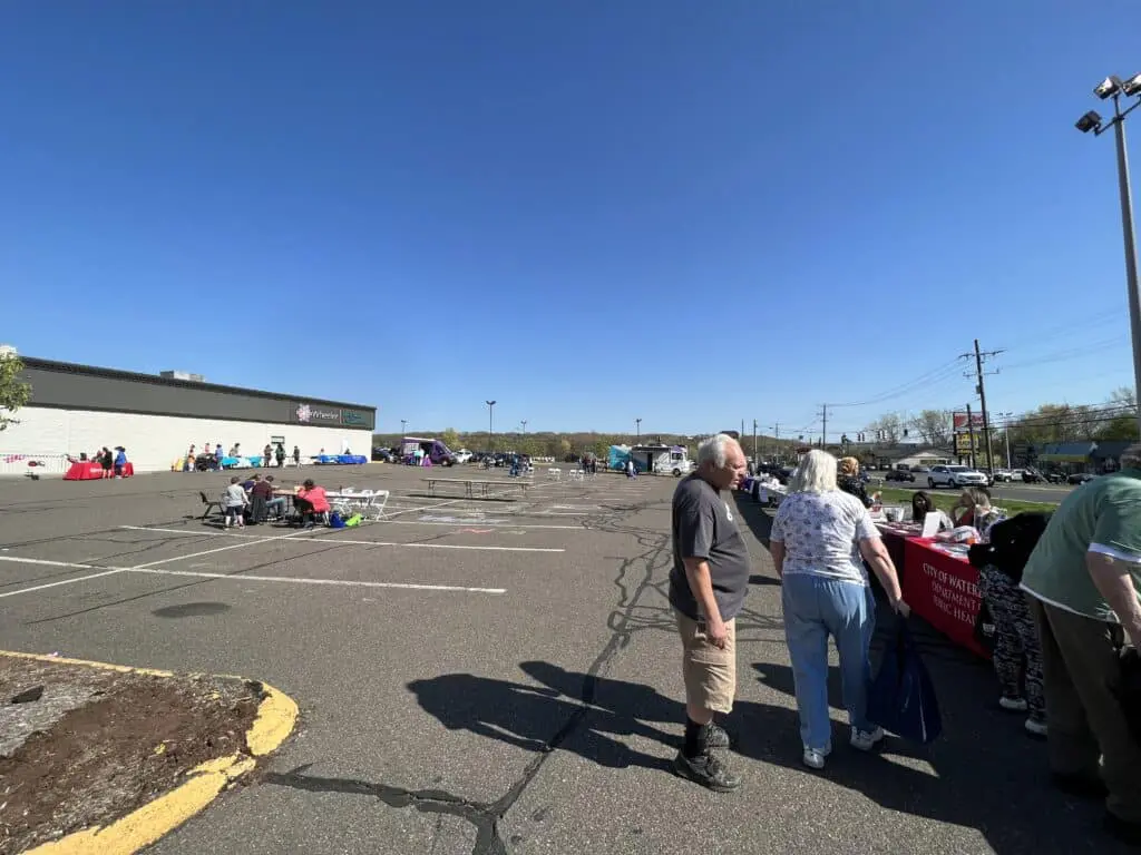 A group of people standing in an empty parking lot.