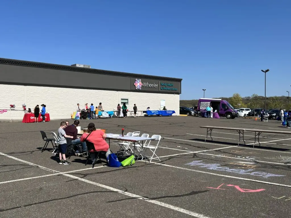 A group of people sitting in the parking lot