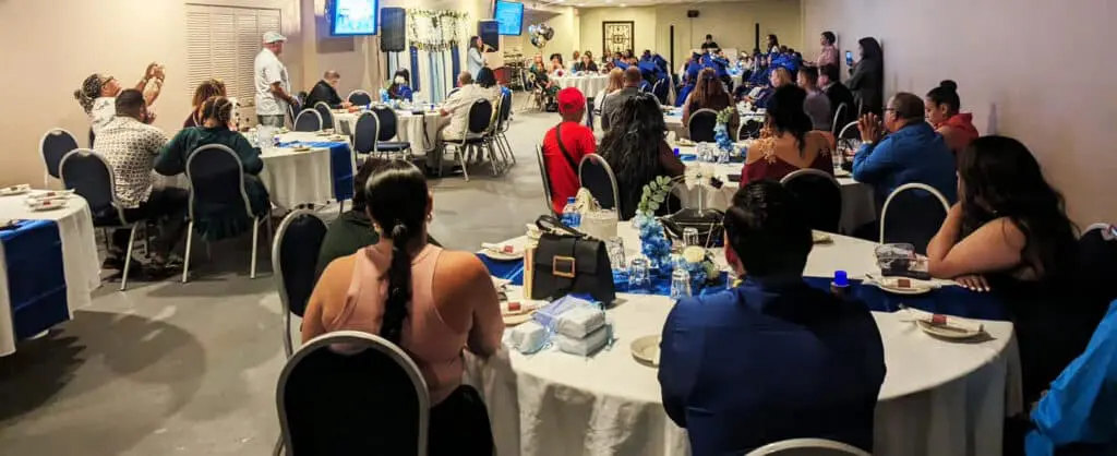 A group of people sitting at tables with water bottles.