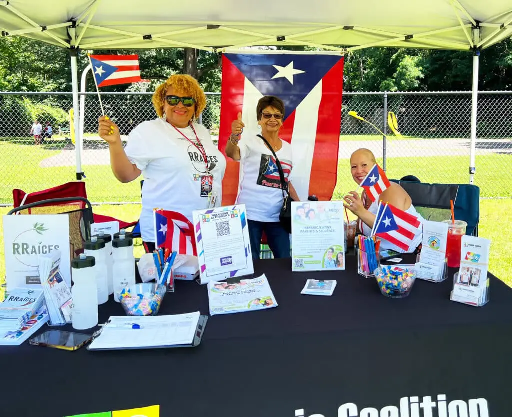 Two women standing next to a table with flags.