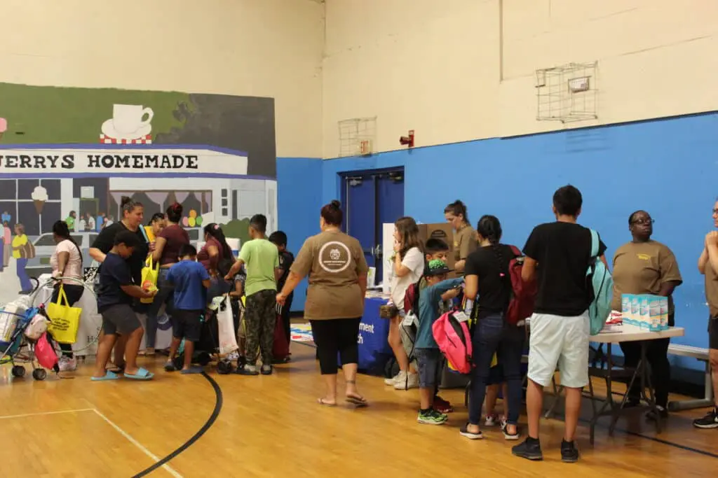 A group of people standing around in a gym.