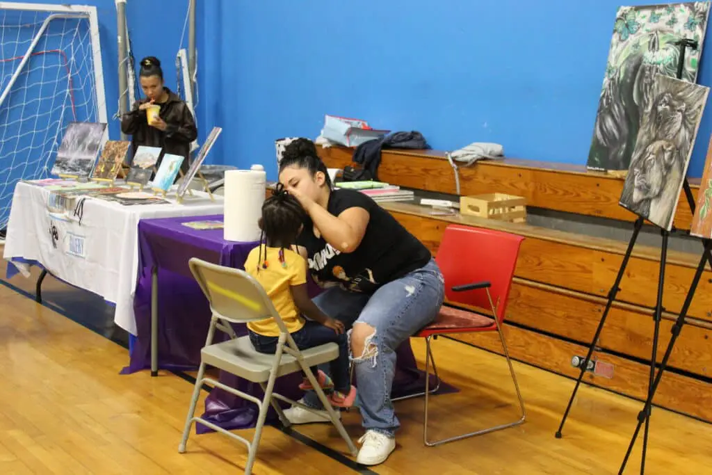 A woman sitting on top of a chair next to a child.