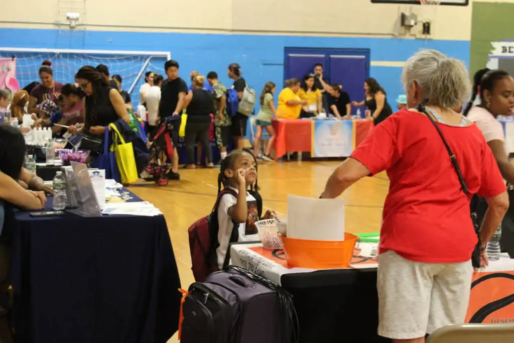 A woman standing in front of a table with papers.