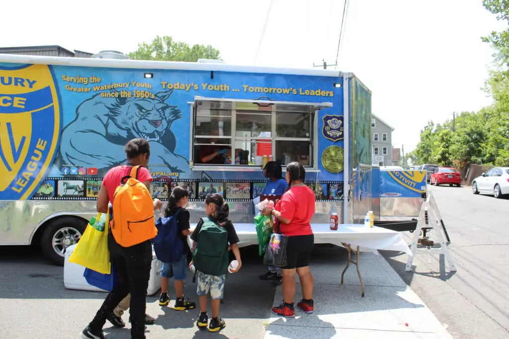 A group of people standing around a food truck.