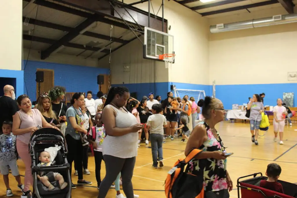 A group of people standing around in a gym.
