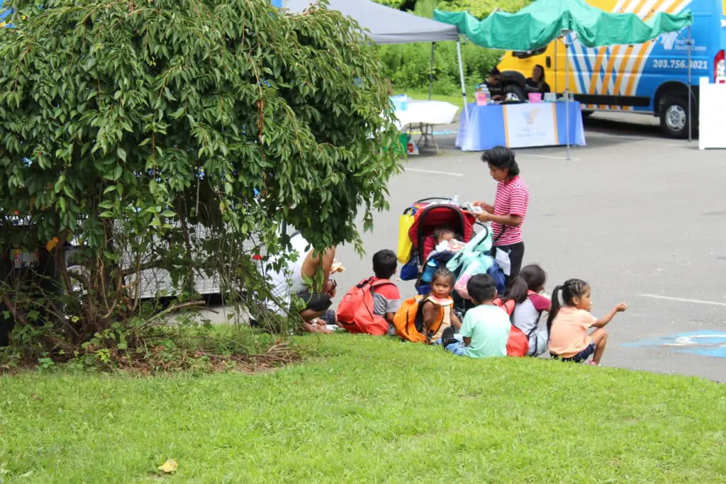 A group of children sitting around in the grass.