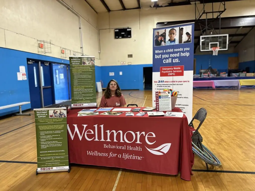 A woman sitting at the table of wellmore.