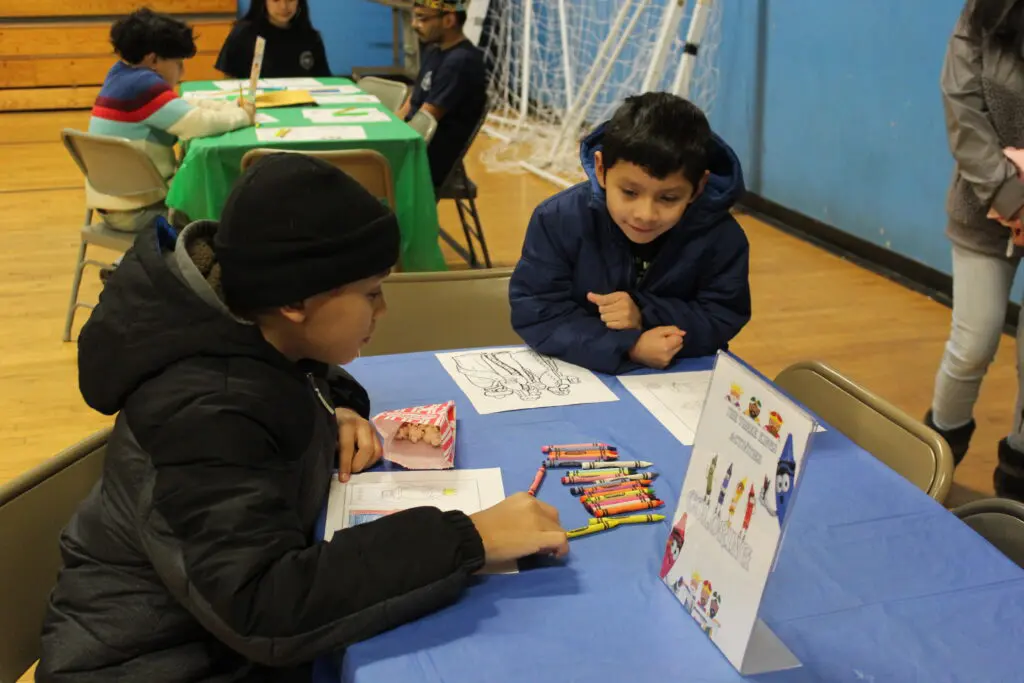 Two children sitting at a table with cards