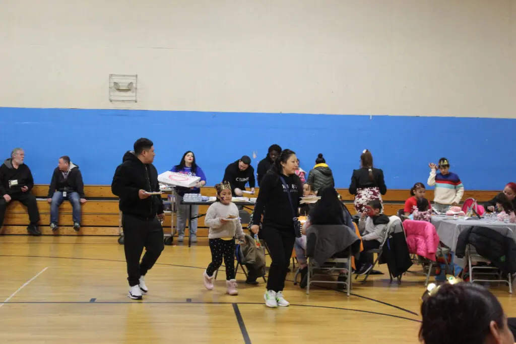 A group of people sitting in the gym.