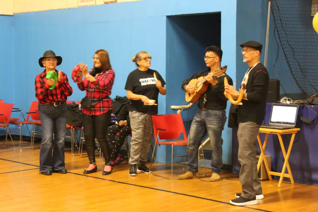 A group of people standing on stage playing instruments.