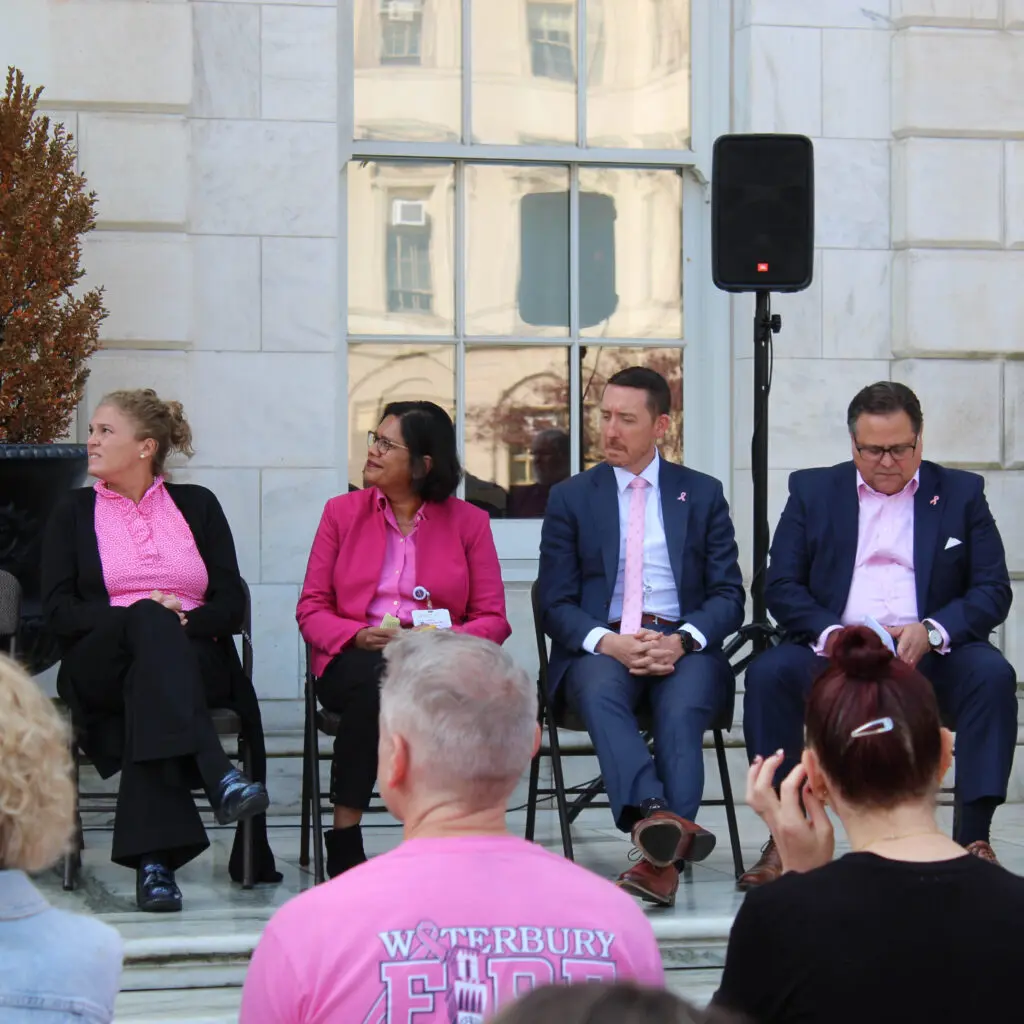 A group of people sitting on chairs in front of a building.