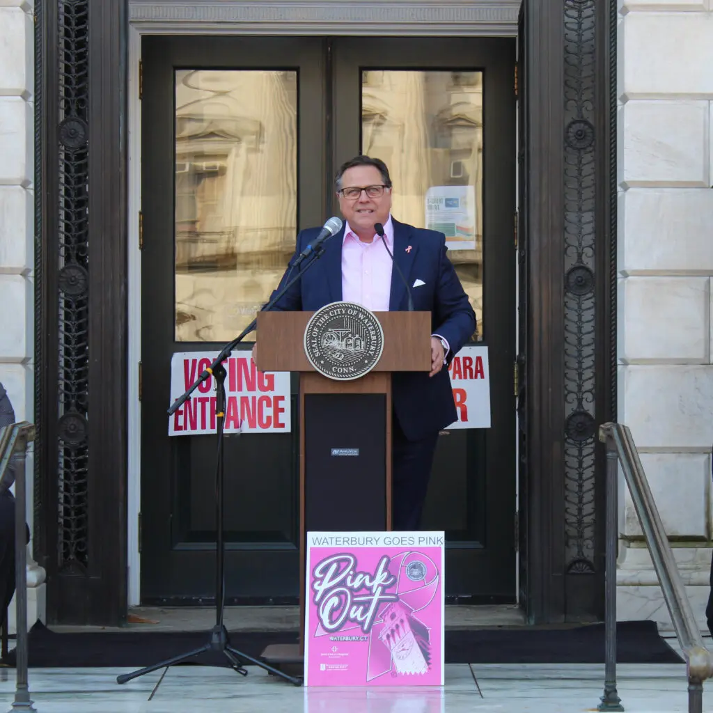 A man standing at the podium in front of a building.