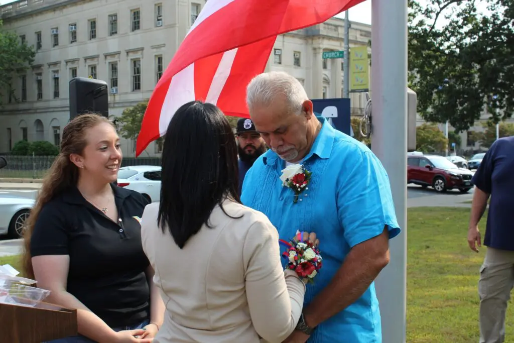 People gathered under a red and white flag.
