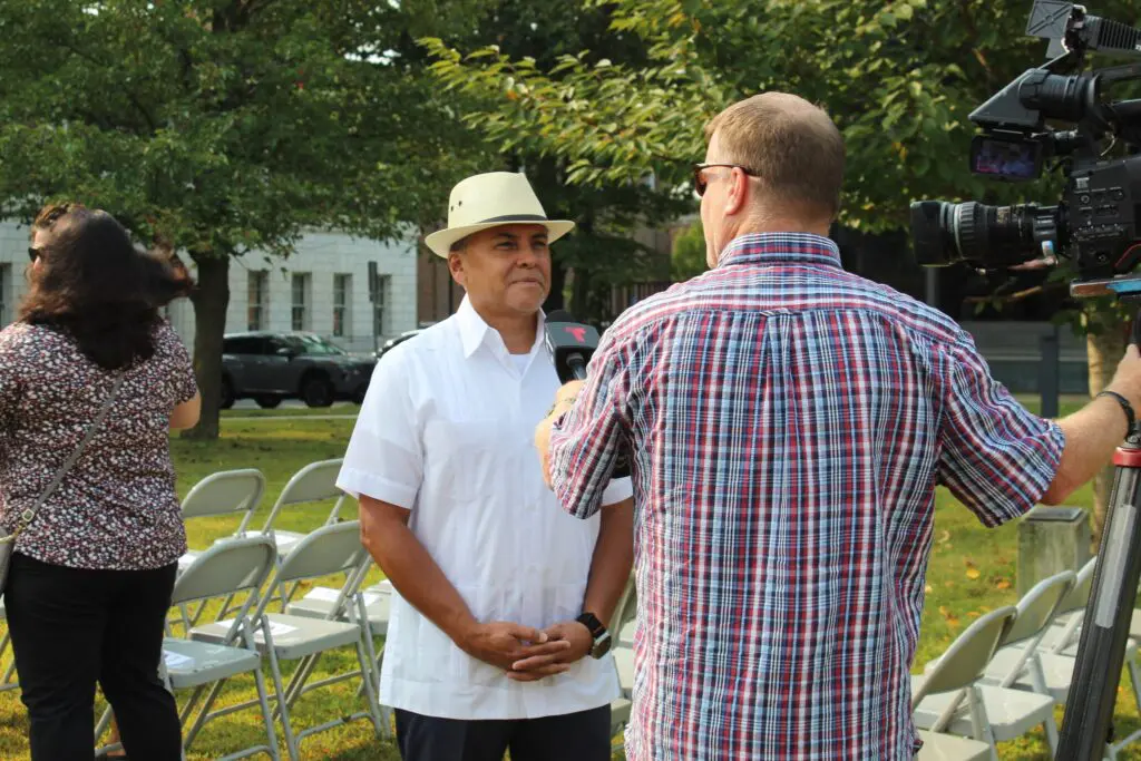 Man interviewed outdoors by cameraman.