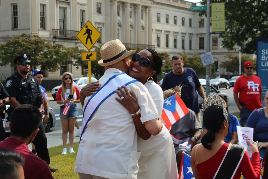 People embracing at outdoor cultural event.