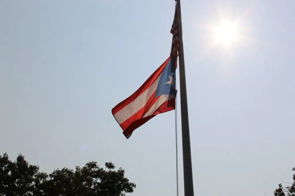 Puerto Rican flag waving under bright sun.