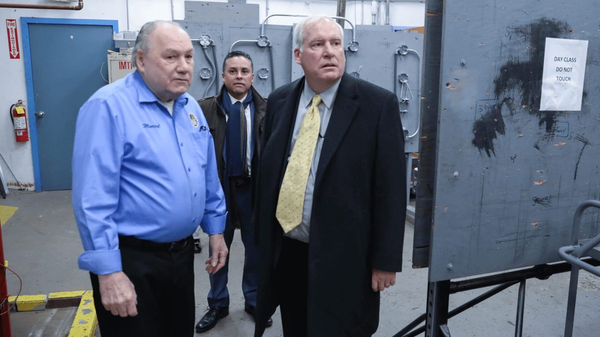 Three men in suits and ties standing next to each other.