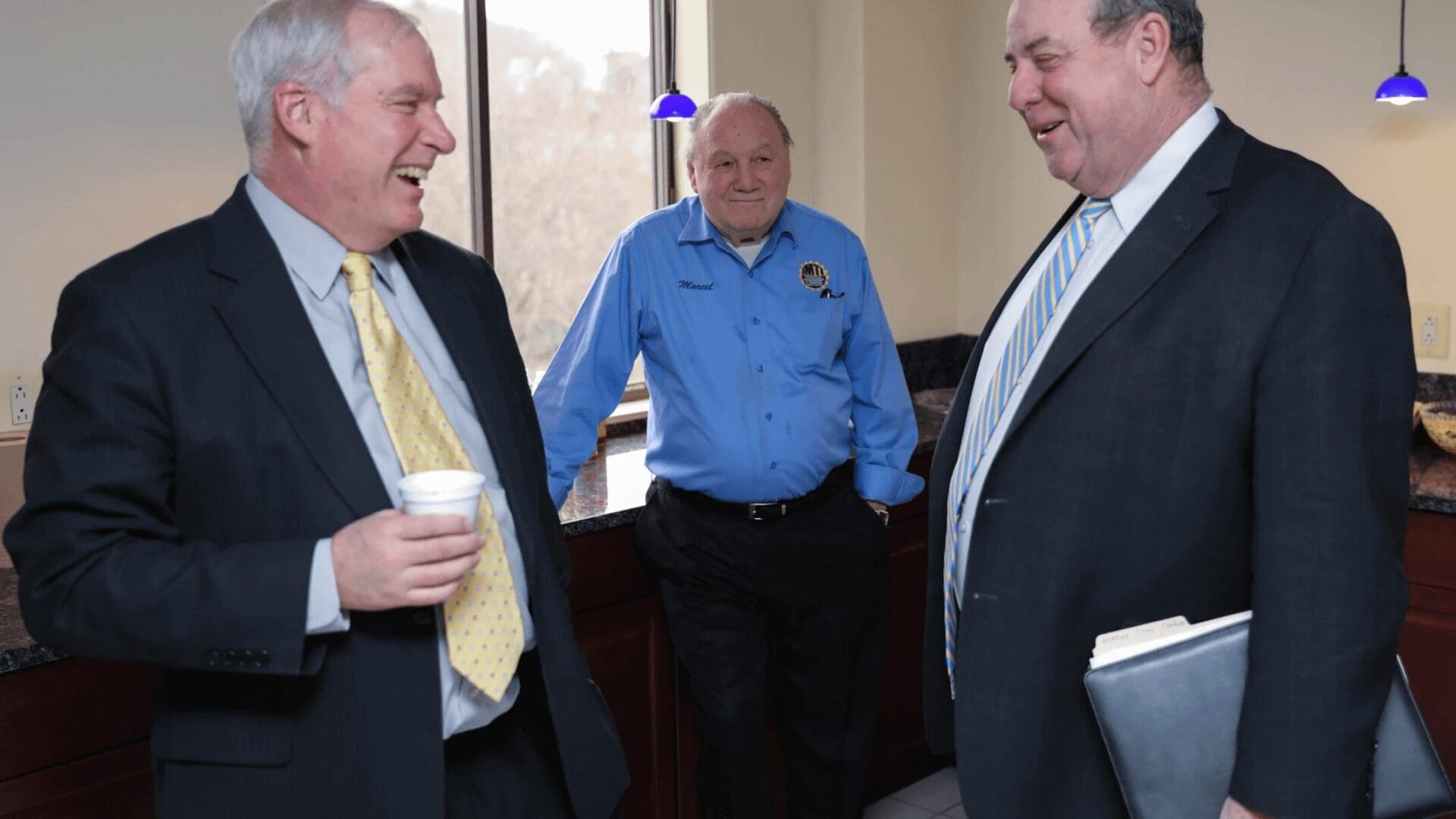 Three men in suits and ties talking to each other.