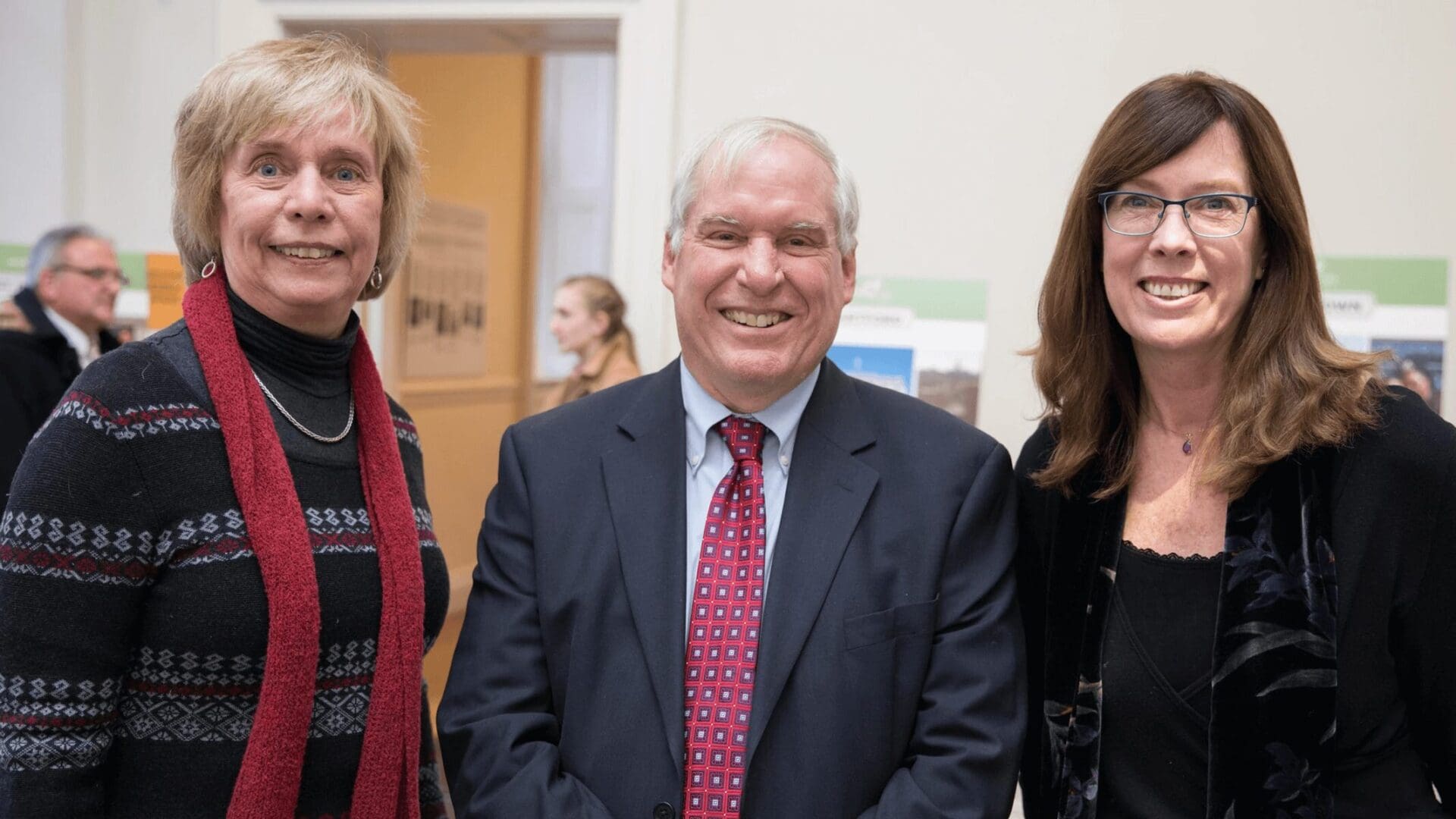 Three people standing next to each other in a room.