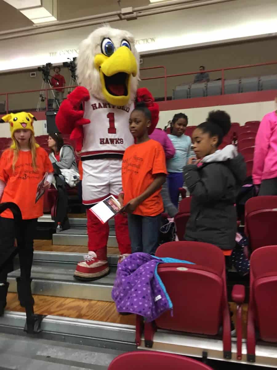 A group of people standing around a mascot.