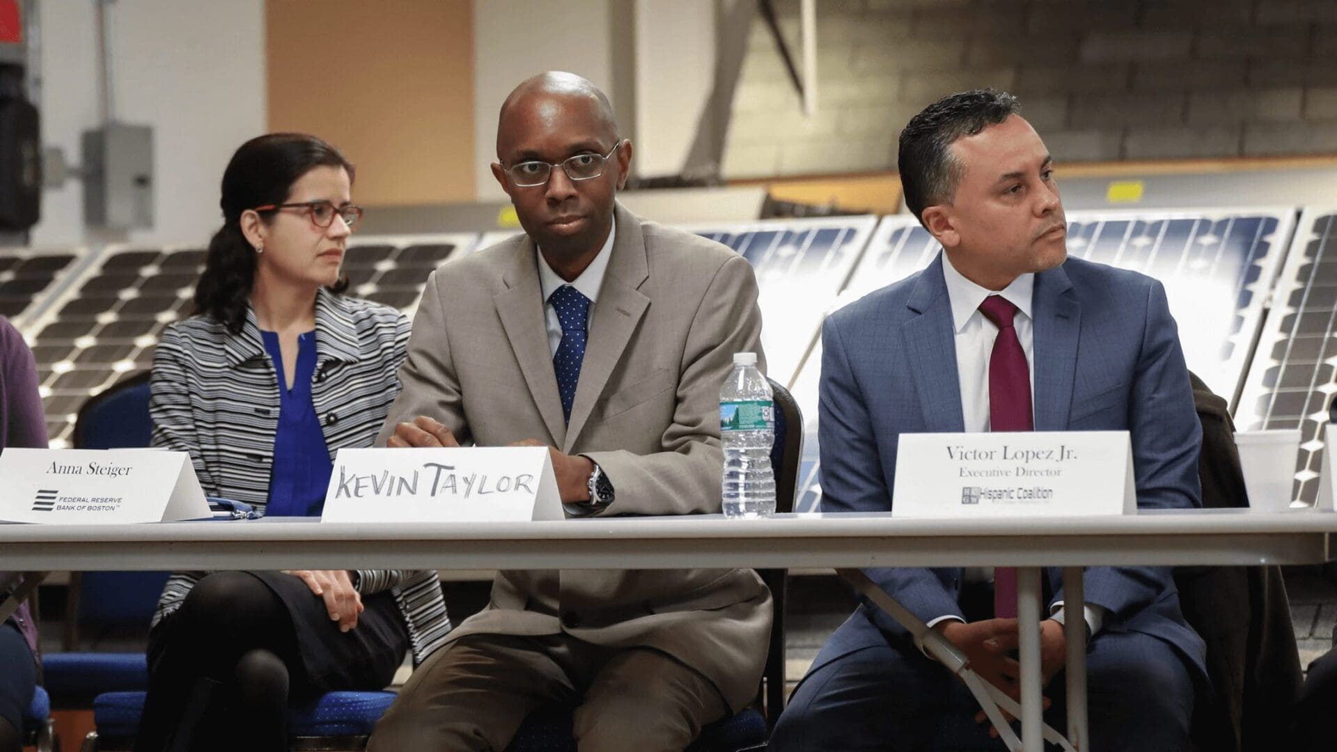 Three people sitting at a table with papers on them.