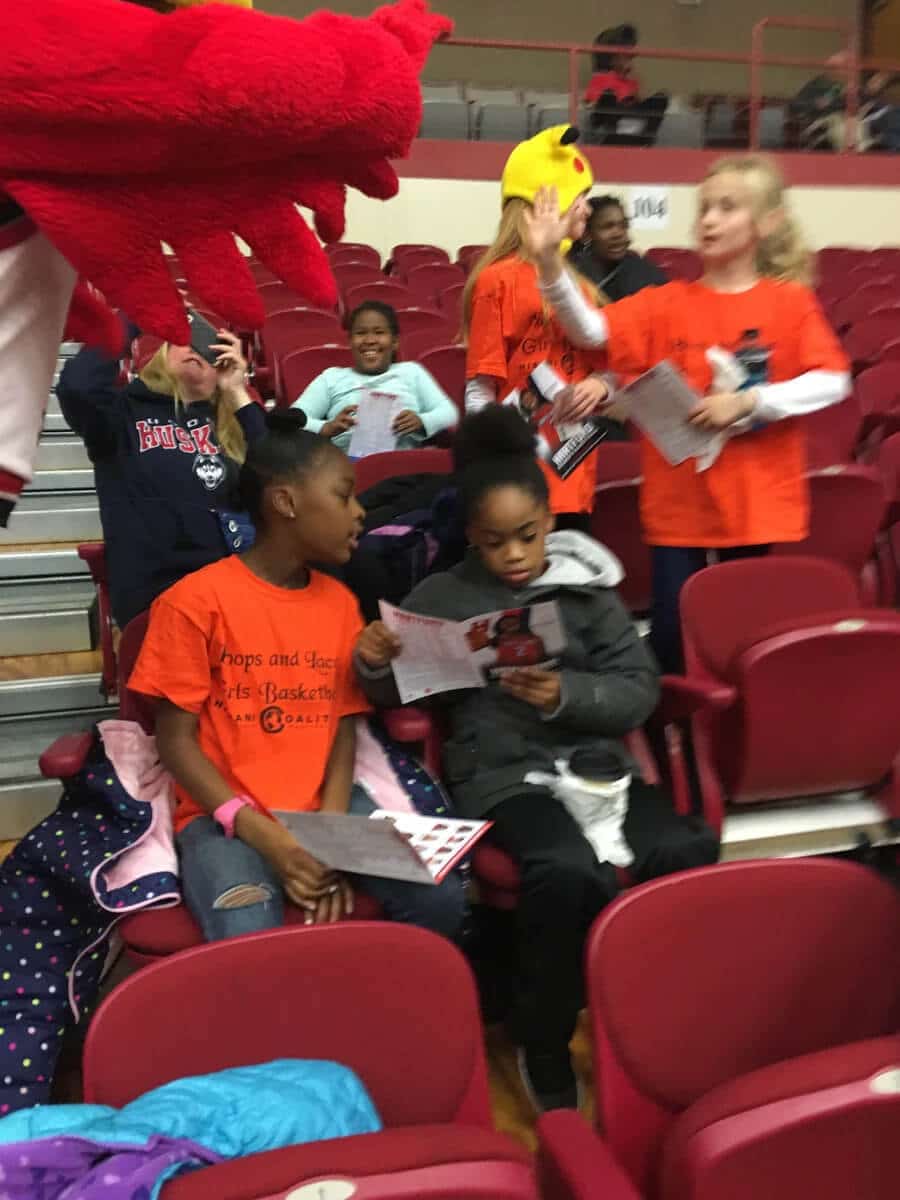 A group of children sitting in chairs at an event.