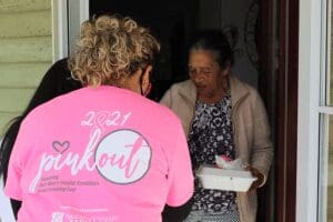 Woman in pink shirt with 2021 pinkout logo.