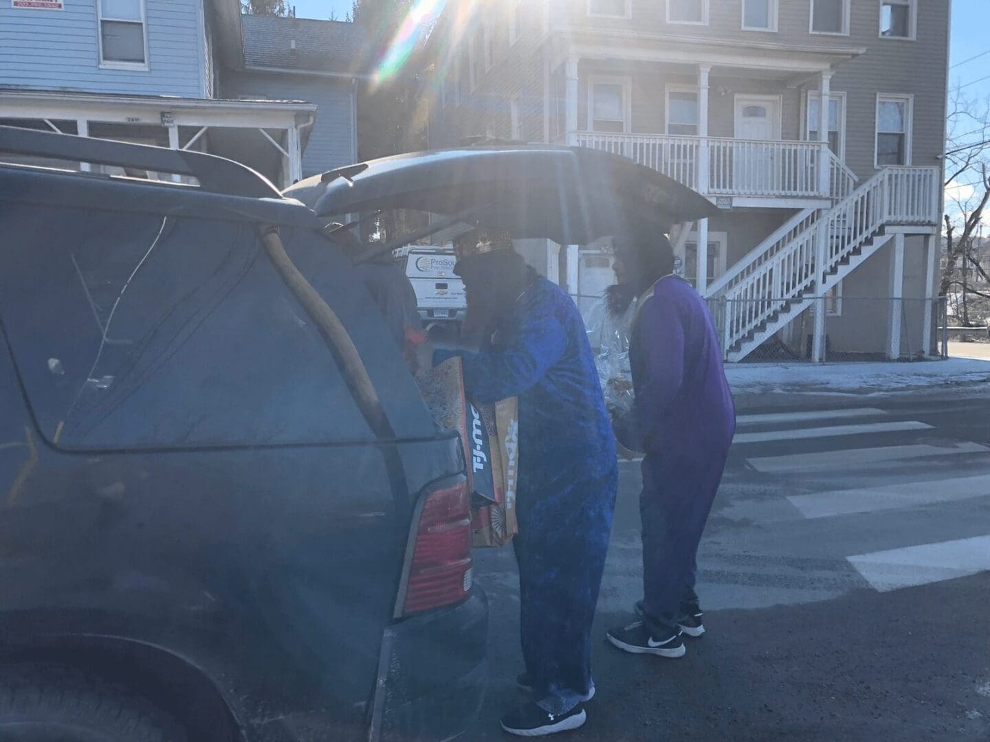 Two people standing under an umbrella on a street.