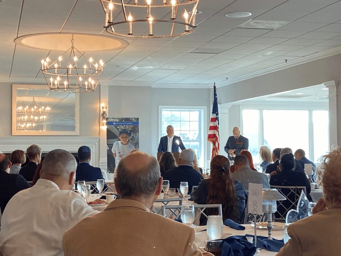 A luncheon with speakers and an American flag.