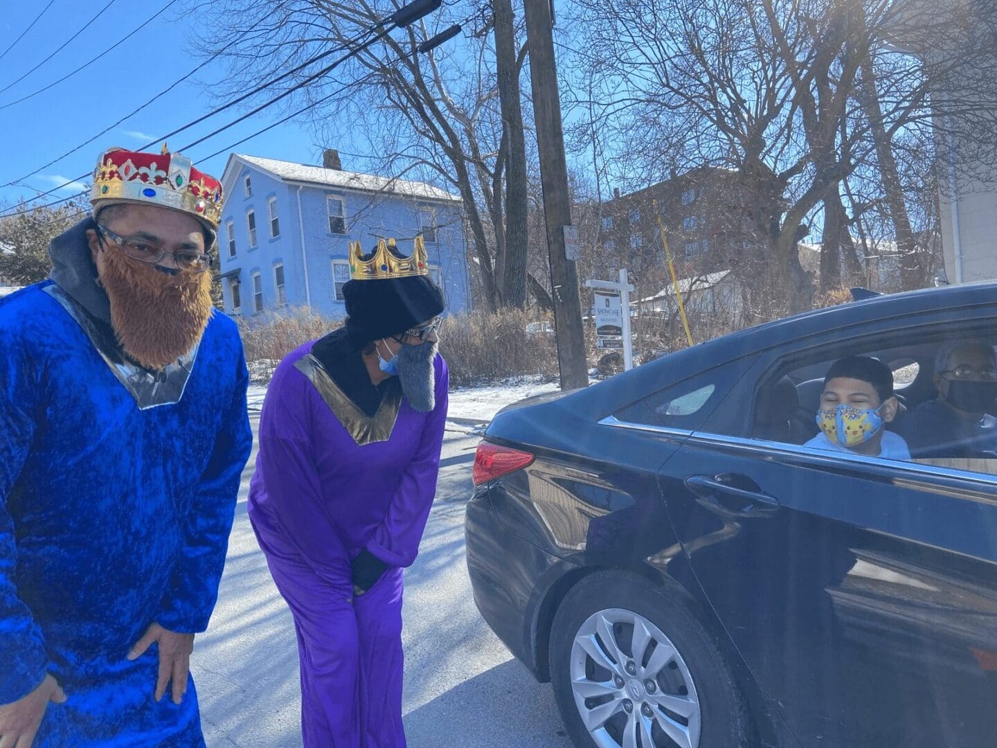 Two people dressed as kings and a car