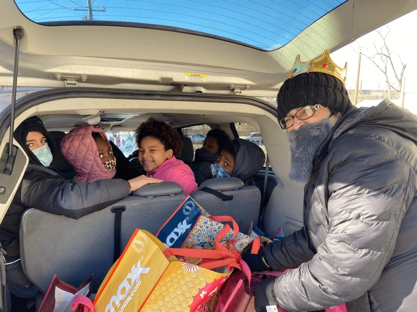 Man with crown helps load groceries.