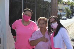 Three women in pink wearing face masks.