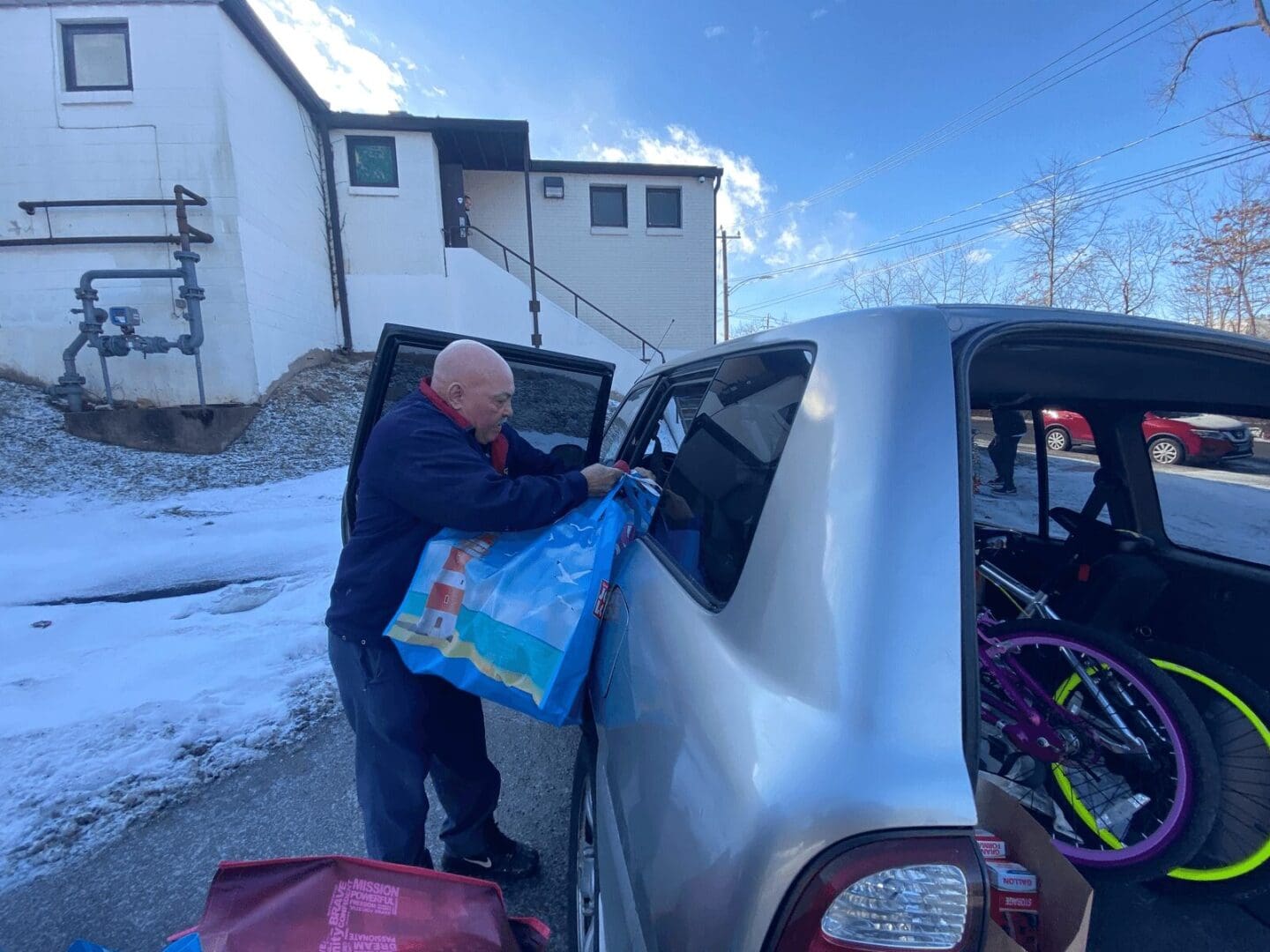 Man loading groceries into a car.